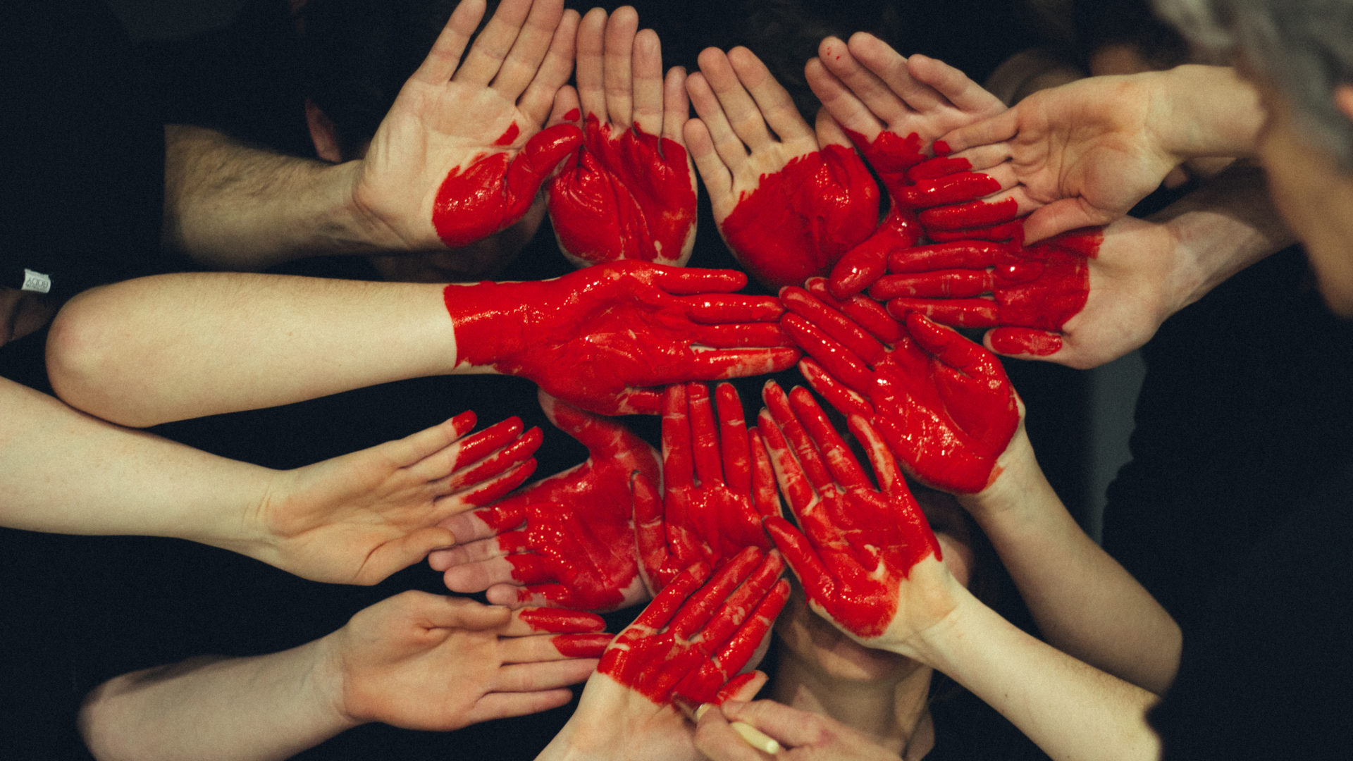 Zdjęcie serca utworzonego z pomalowanych na czerwono dłoni