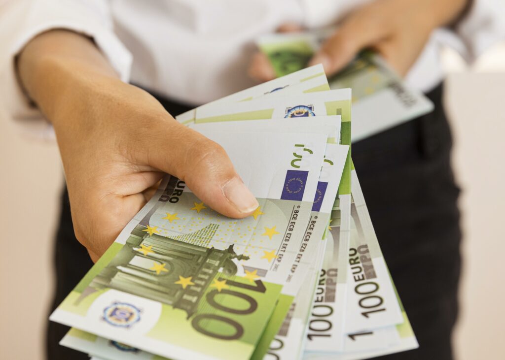 Zdjęcie przedstawia banknoty trzymane w dłoni.